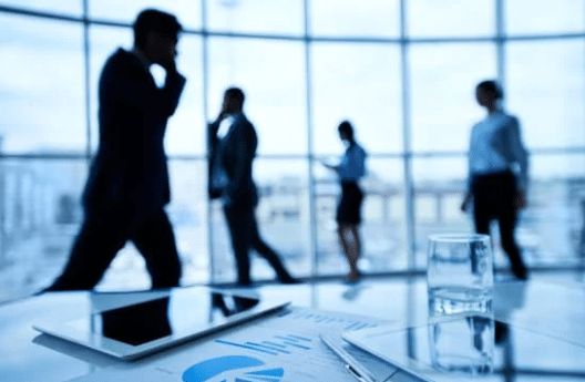 Vue d’une entreprise avec plusieurs personnes floutées au téléphone, illustrant le travail en équipe et le service client professionnel.
